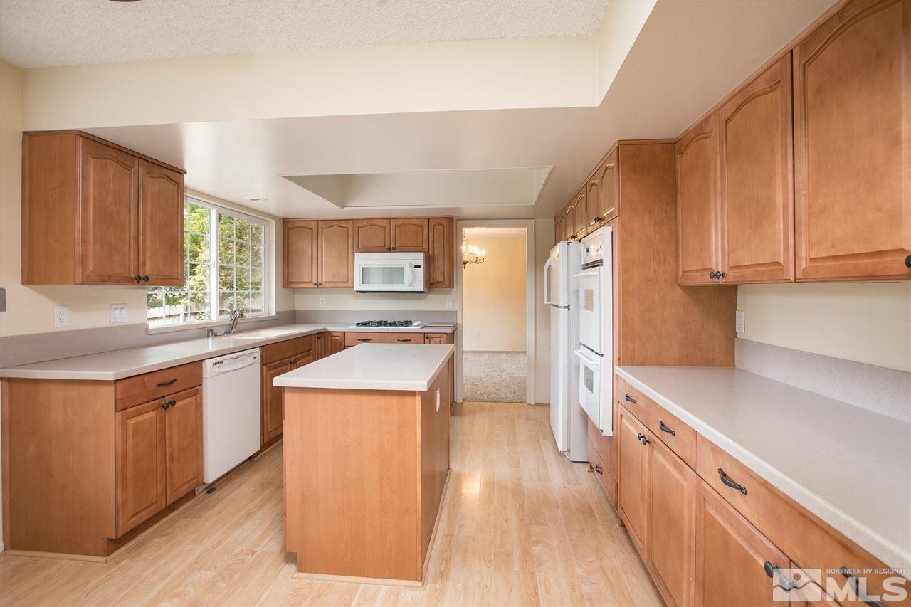 885 Twin Pines Road Reno, NV 89509 - Photo 6 of 25 a kitchen with stainless steel appliances granite countertop wooden cabinets a sink and a stove