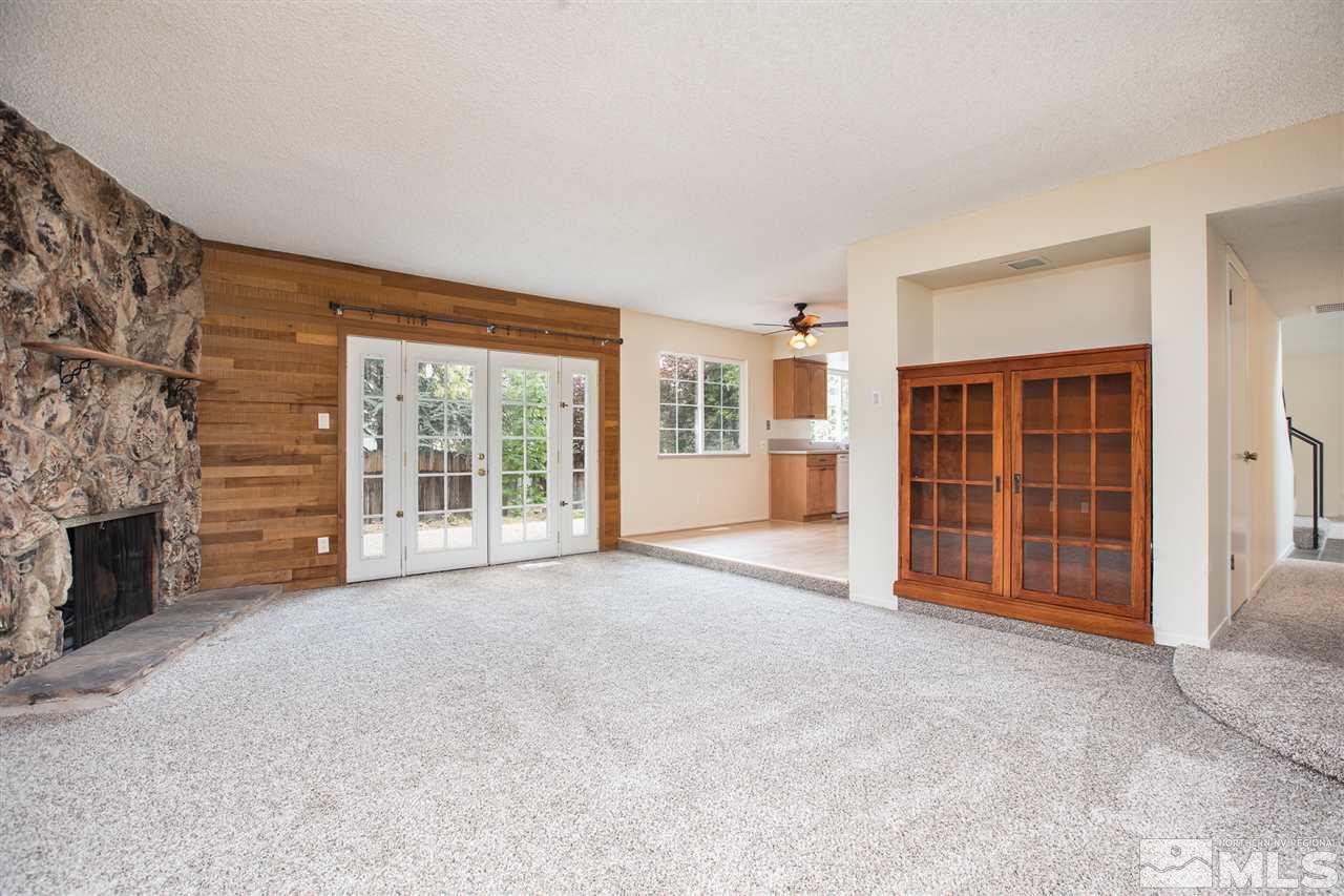 885 Twin Pines Road Reno, NV 89509 - Photo 9 of 25 a view of an empty room with a fireplace and a window