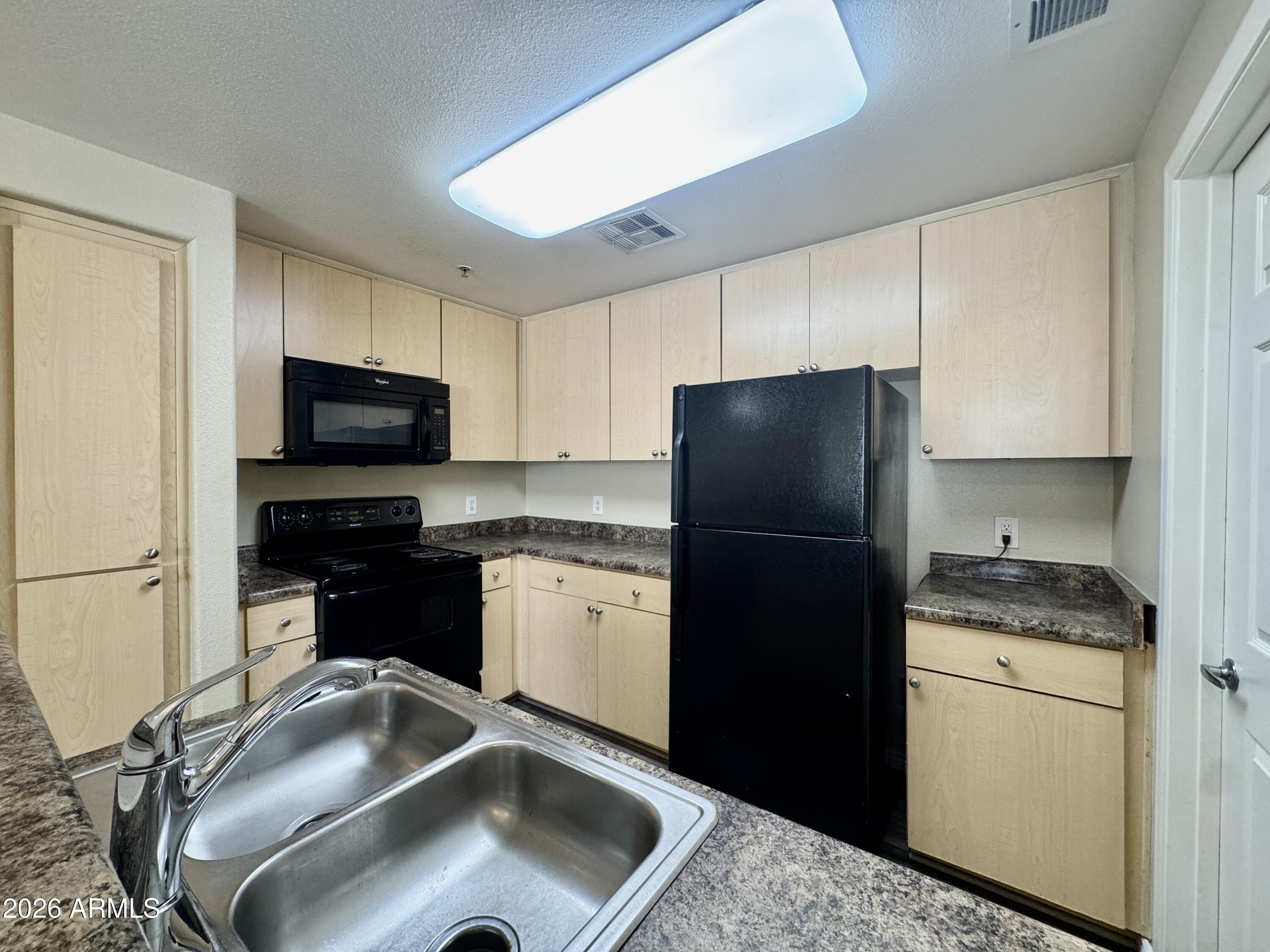 18416 North Cave Creek Road, Unit 2033 Phoenix, AZ 85032 - Photo 3 of 18 a kitchen with a sink stove and refrigerator