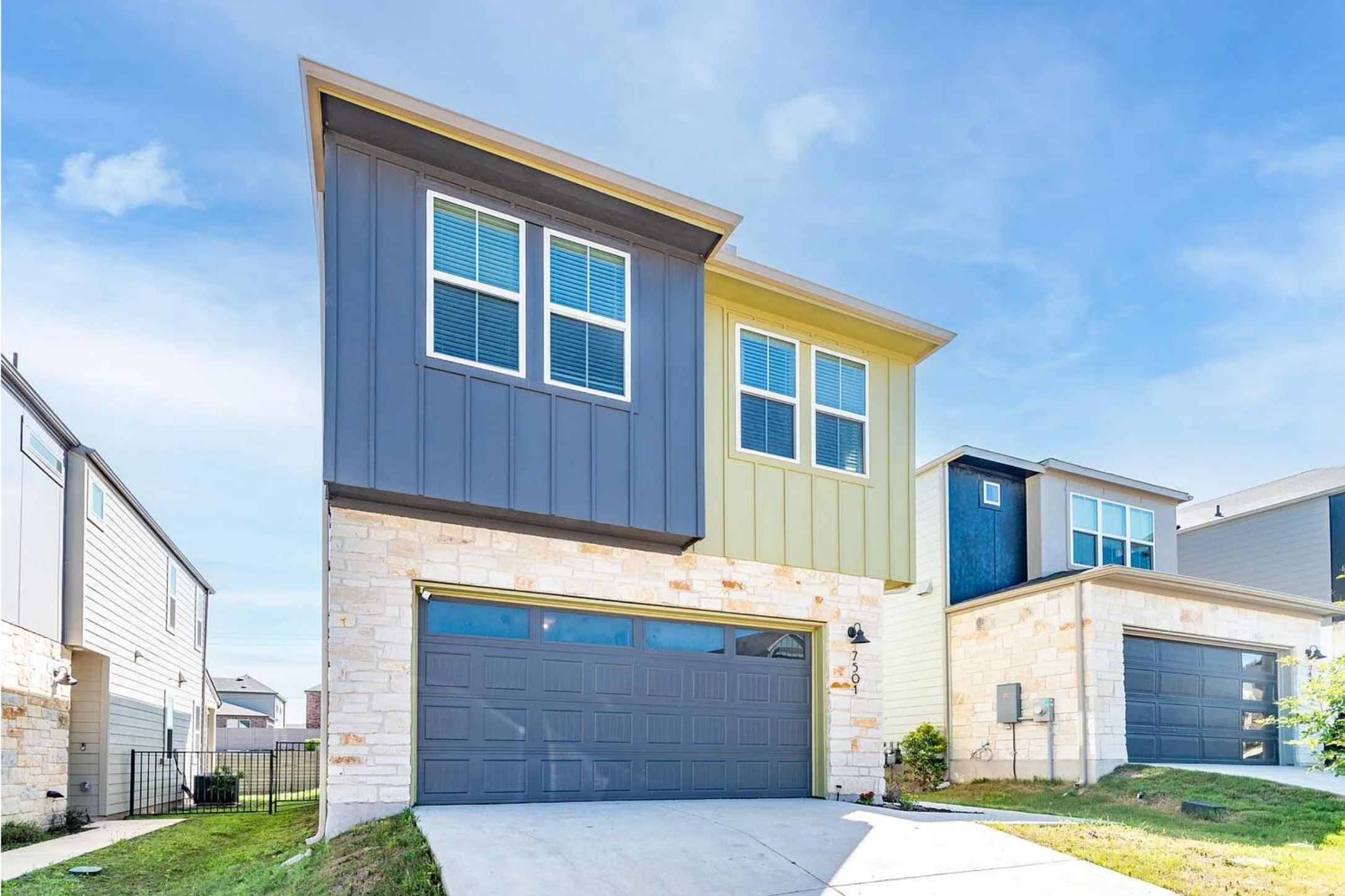 7501 Travertine Spring Drive Austin, TX 78744 - Photo 2 of 28 Contemporary exterior featuring stone accents and vertical siding in contrasting colors