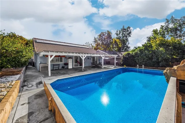 a view of house with swimming pool outdoor seating