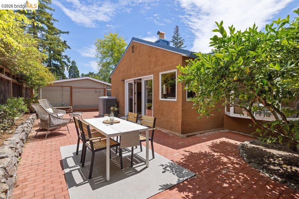 287 Purdue Avenue Kensington, CA 94708 - Photo 33 of 60 Brick paver patio featuring an earth-toned stucco exterior, white-framed windows, and sliding glass patio doors