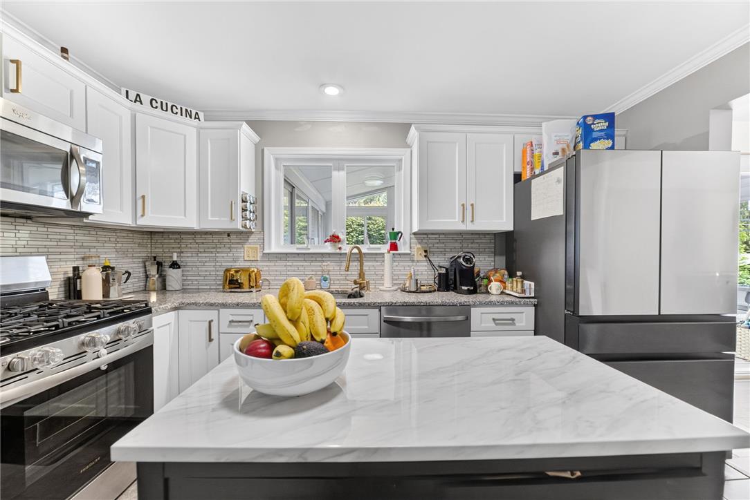 7290 Heather Road Macungie, PA 18062 - Photo 16 of 39 White cabinetry, sleek appliances, and a marble-like island elevate this culinary space.