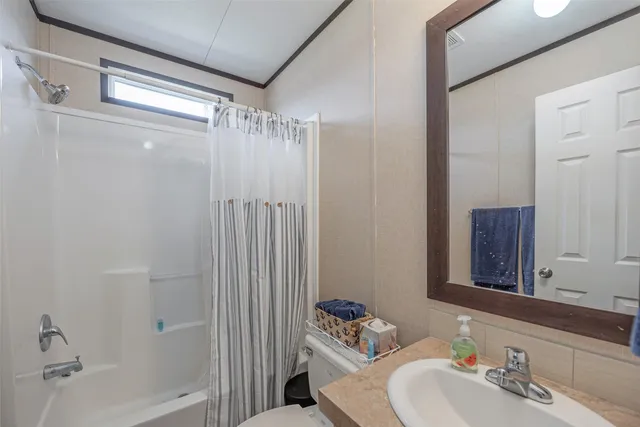 a bathroom with a sink and mirror with bathtub