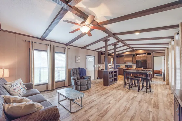 a living room with furniture dining table a large window and potted plants