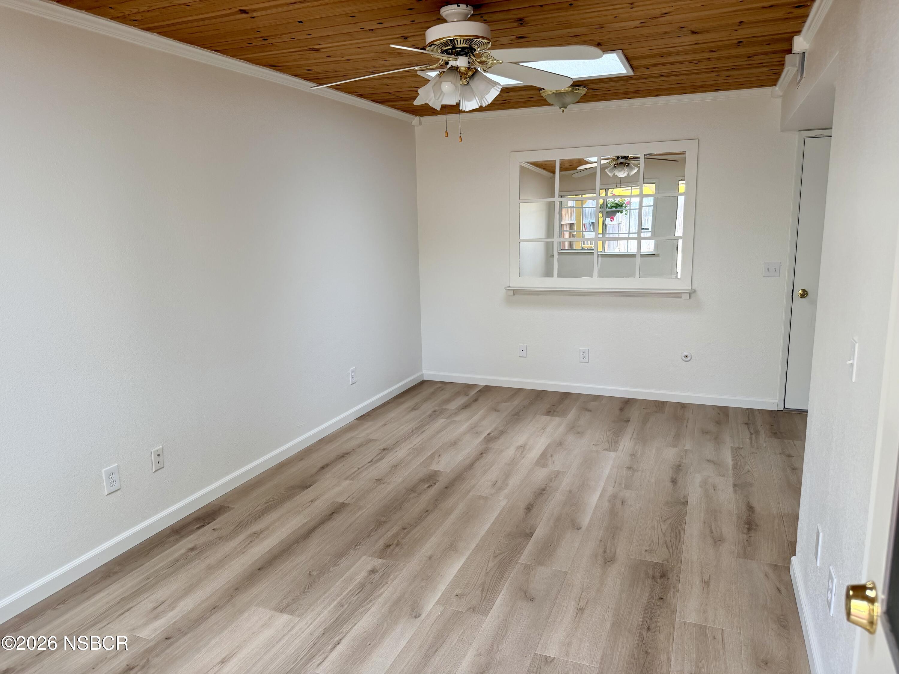 181 Janet Avenue Grover Beach, CA 93433 - Photo 11 of 21 an empty room with a chandelier fan and windows