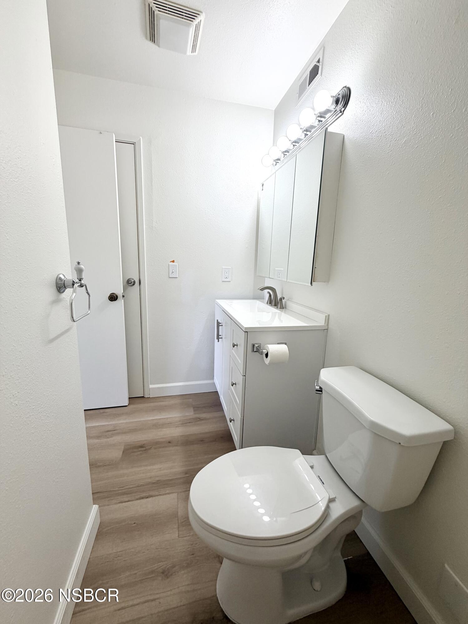 181 Janet Avenue Grover Beach, CA 93433 - Photo 17 of 21 a bathroom with a sink a toilet a mirror and vanity