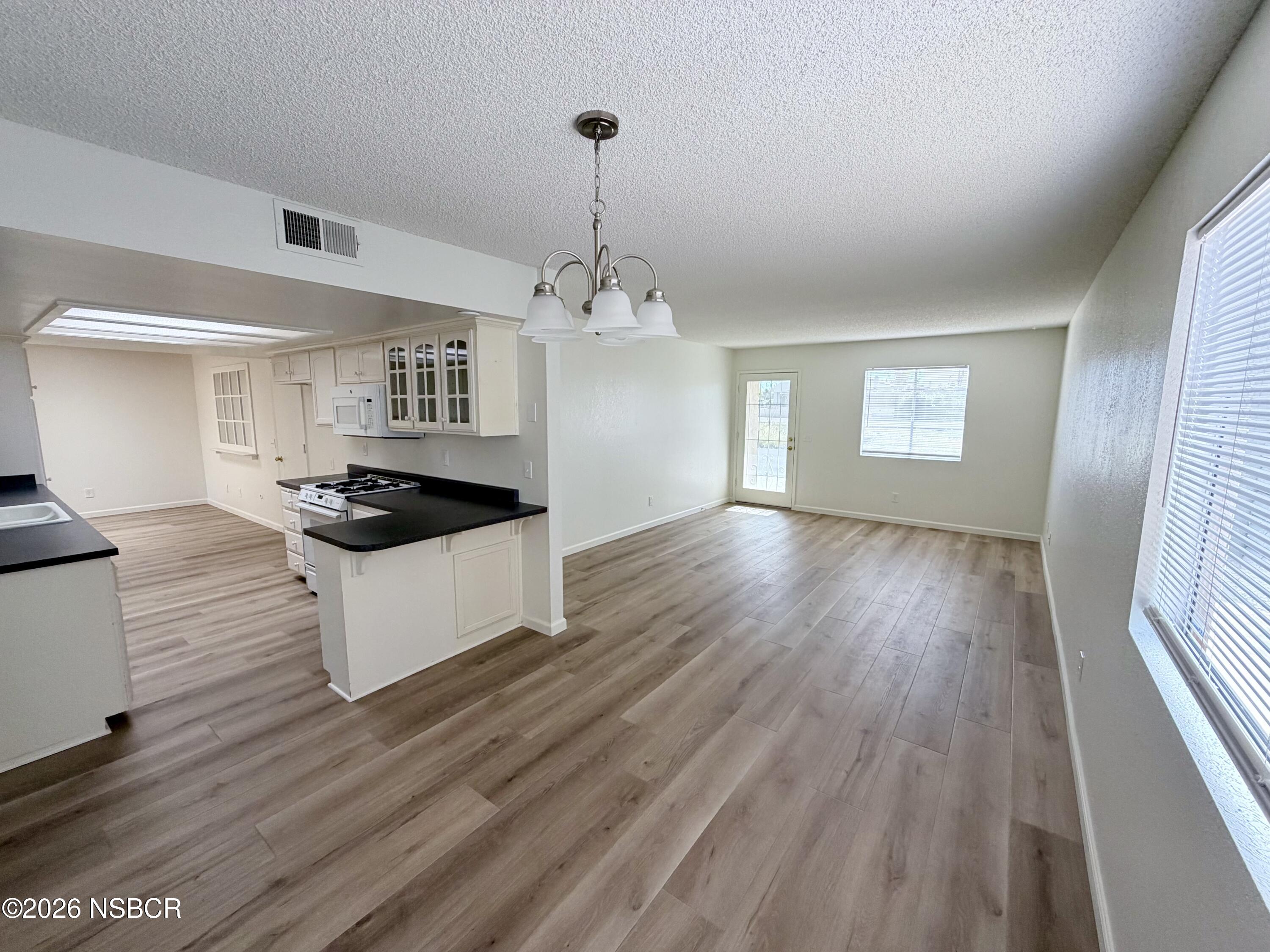 181 Janet Avenue Grover Beach, CA 93433 - Photo 6 of 21 a kitchen with wooden floors and white appliances