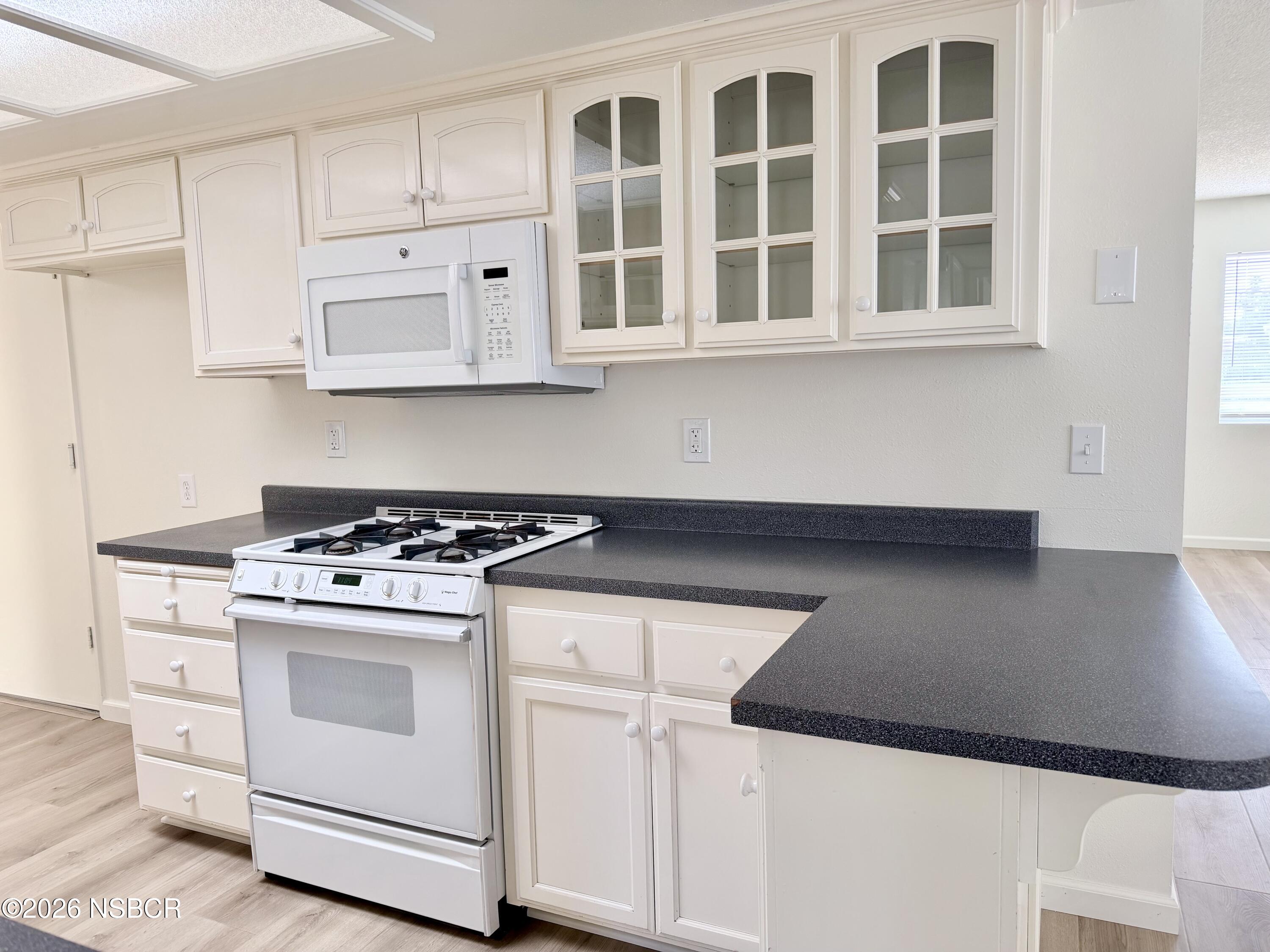 181 Janet Avenue Grover Beach, CA 93433 - Photo 9 of 21 a kitchen with granite countertop white cabinets and white appliances