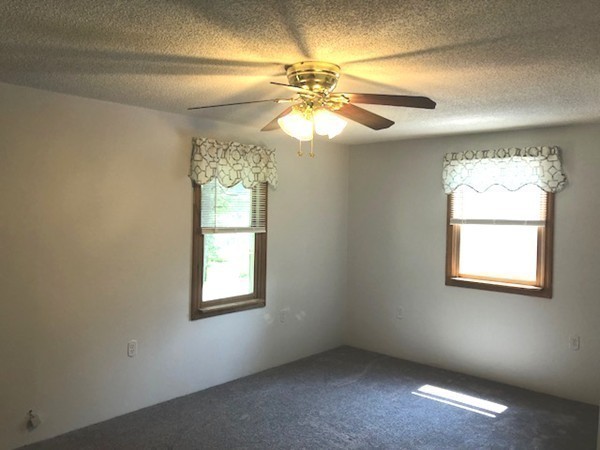 15 Primrose Road Billerica, MA 01821 - Photo 19 of 26 an empty room with windows and chandelier fan