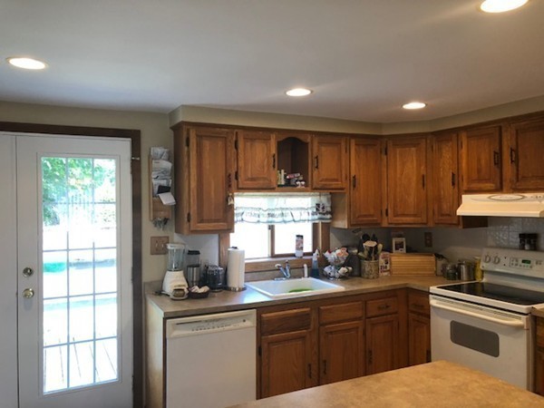 15 Primrose Road Billerica, MA 01821 - Photo 5 of 26 a kitchen with kitchen island granite countertop wooden cabinets a sink a window and stainless steel appliances