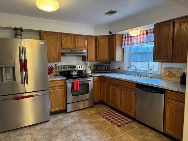 a kitchen with stainless steel appliances granite countertop a refrigerator sink and stove