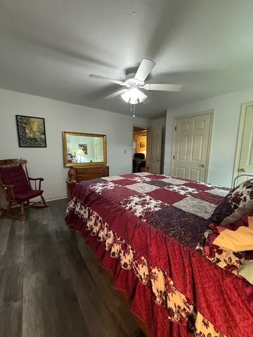 a bedroom with a large bed chandelier and a window