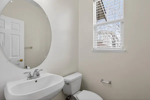 a bathroom with a sink a toilet and a mirror