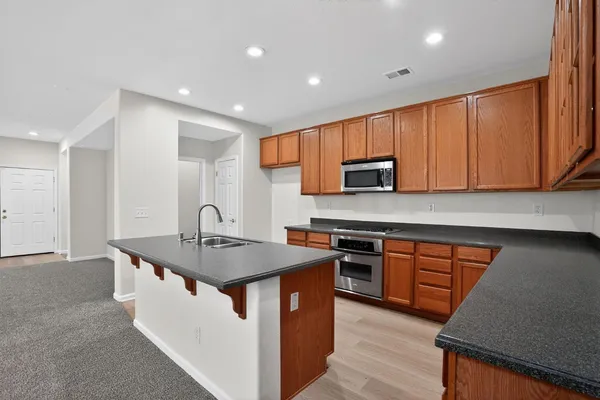 a kitchen with stainless steel appliances granite countertop a sink stove and microwave