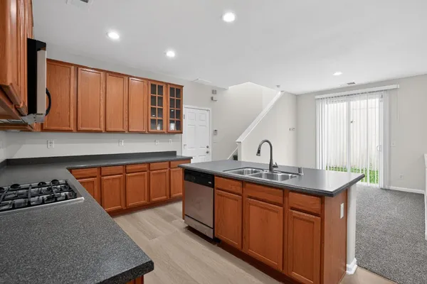 a kitchen with stainless steel appliances granite countertop a sink stove and cabinets