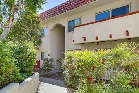 a front view of a house with plants and entryway