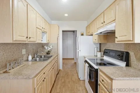 a kitchen with granite countertop a sink stove and cabinets
