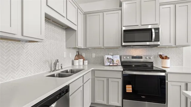 a kitchen with white cabinets and black appliances