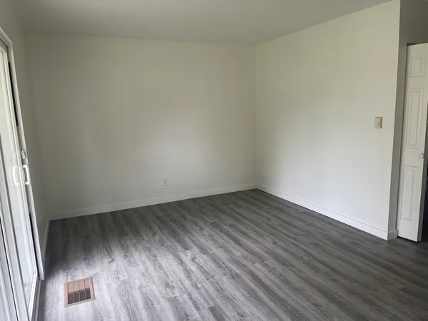 a view of an empty room and wooden floor