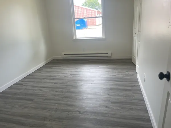 wooden floor in an empty room with a window