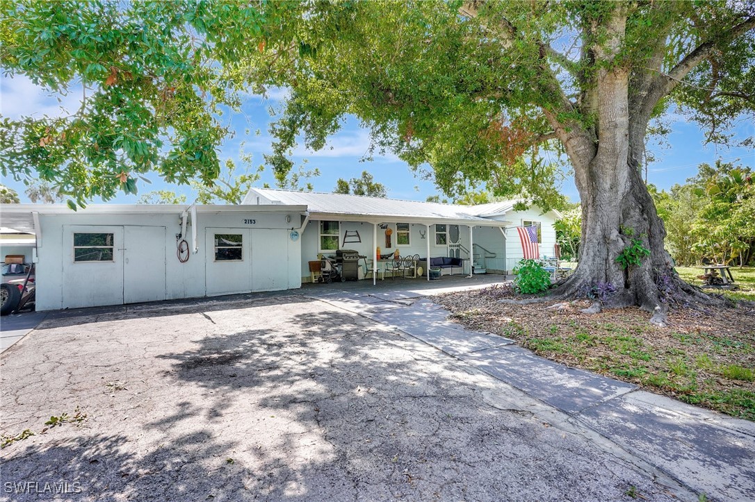 2153 Twin Brooks Road North Fort Myers, FL 33917 - Photo 4 of 31 a view of a house with a yard and large tree