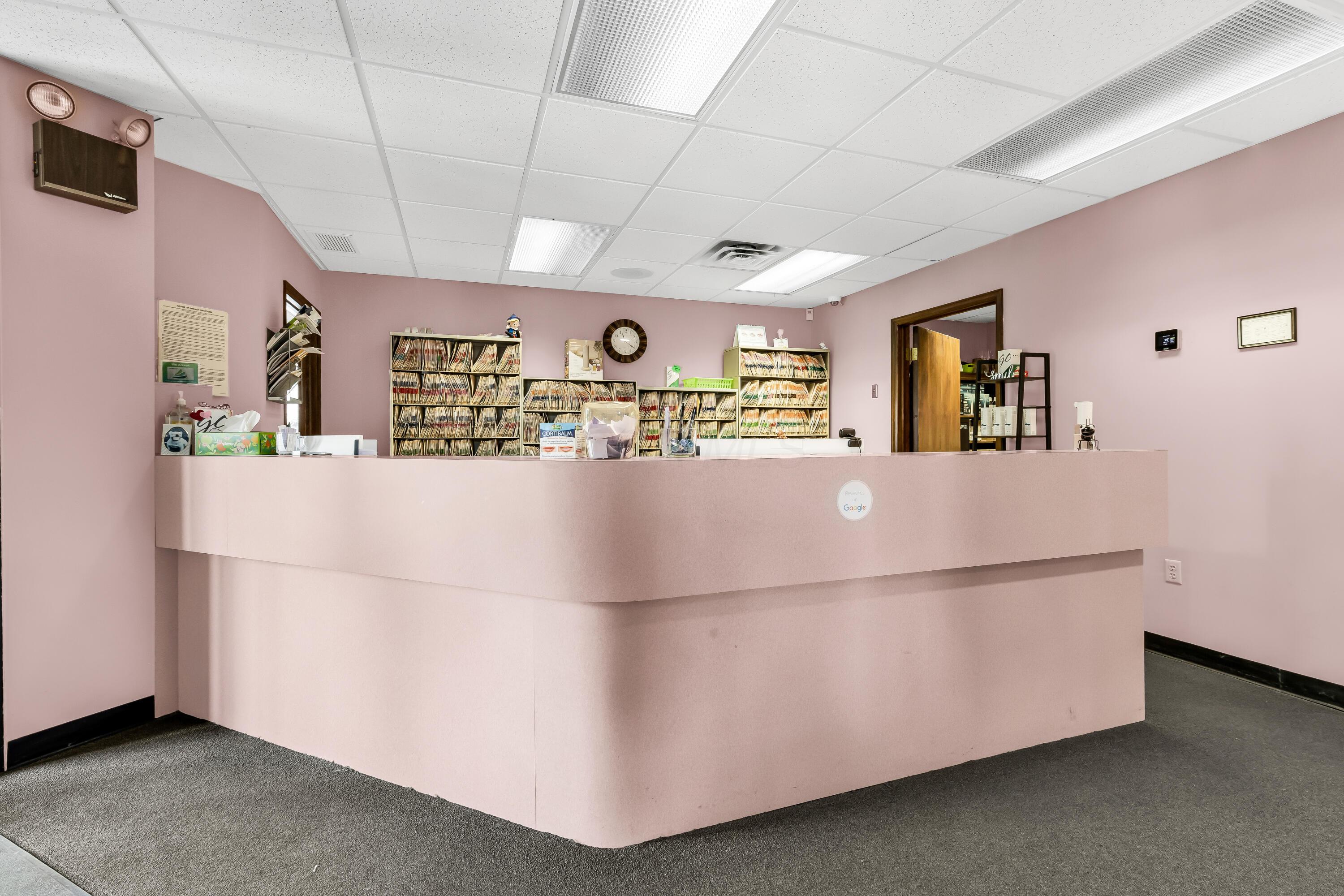 1240 Crescent Heights Road Marion, OH 43302 - Photo 16 of 60 • Blue carpet • Pink painted walls • Acoustic ceiling tiles • Fluorescent lighting • Receptionist counter