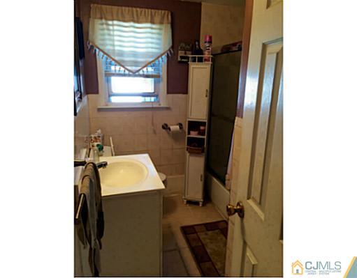 128 Raritan Boulevard Old Bridge, NJ 07735 - Photo 15 of 15 a bathroom with a sink a toilet and mirror