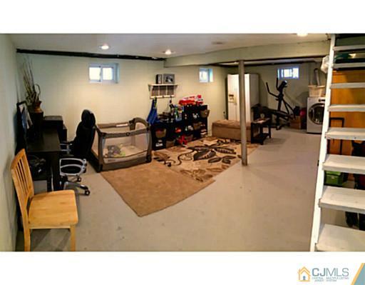 128 Raritan Boulevard Old Bridge, NJ 07735 - Photo 5 of 15 a living room with furniture a gym equipment and a mirror