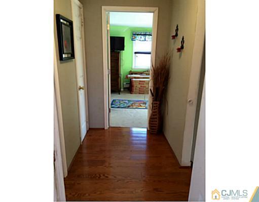 128 Raritan Boulevard Old Bridge, NJ 07735 - Photo 9 of 15 a view of a hallway with wooden floor and a living room