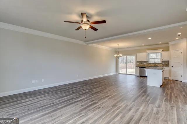 a view of empty room with wooden floor and window