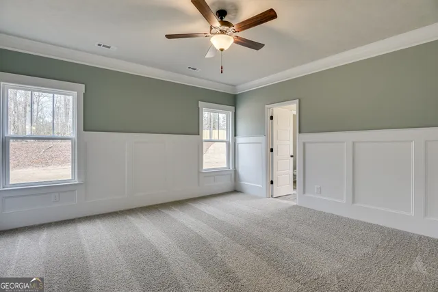 a view of empty room with window and ceiling fan