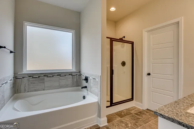 a bathroom with a granite countertop tub shower and sink