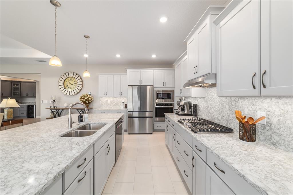 9681 Southwest 82nd Street Road Ocala, FL 34481 - Photo 14 of 62 a large kitchen with stainless steel appliances granite countertop a sink stove and refrigerator