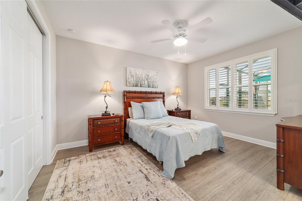 9681 Southwest 82nd Street Road Ocala, FL 34481 - Photo 28 of 62 a bedroom with a large bed and a chandelier