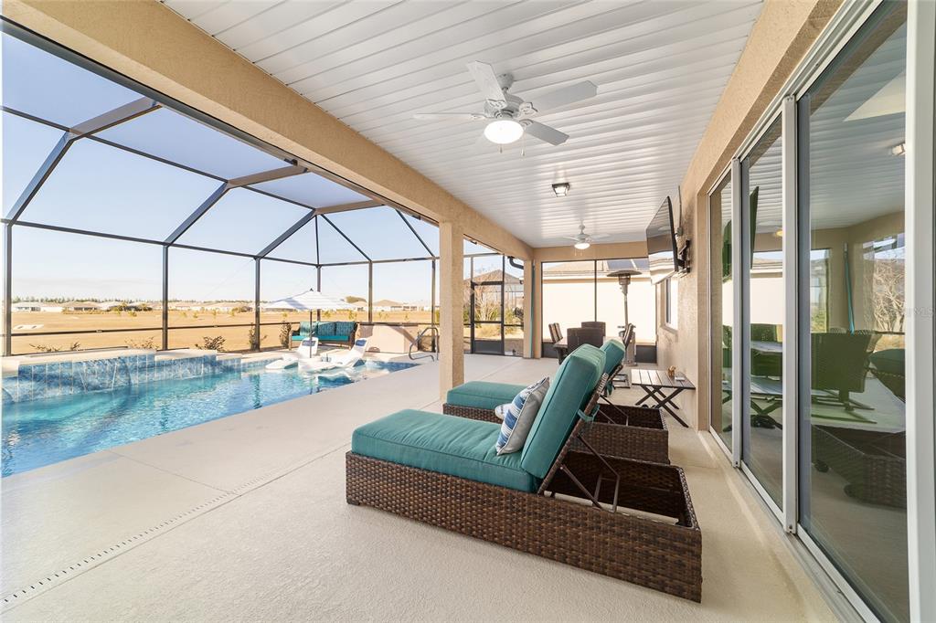 9681 Southwest 82nd Street Road Ocala, FL 34481 - Photo 35 of 62 a living room with furniture floor to ceiling windows and a ceiling fan