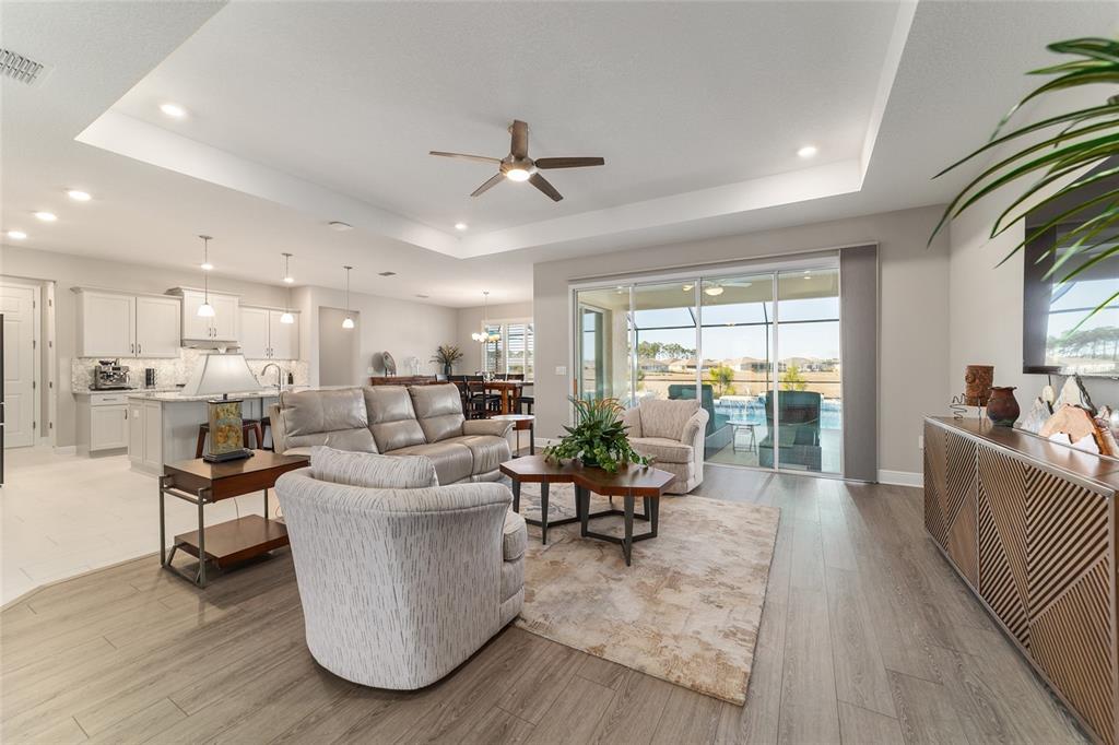 9681 Southwest 82nd Street Road Ocala, FL 34481 - Photo 9 of 62 a living room with couches and kitchen view with wooden floor