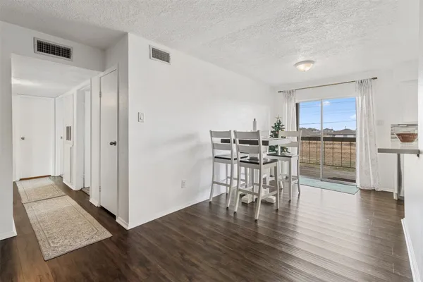 a view of a kitchen with dining table chairs and wooden floor