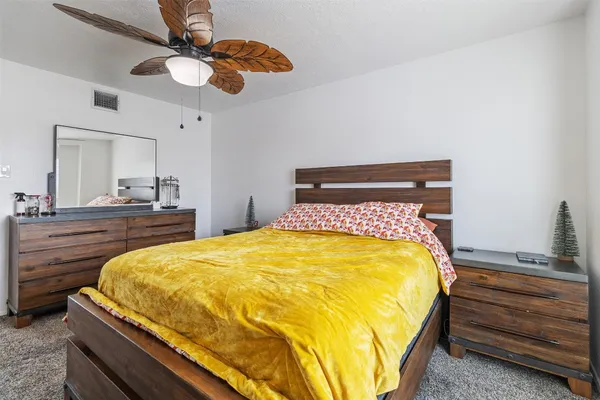 a bedroom with a bed and ceiling fan