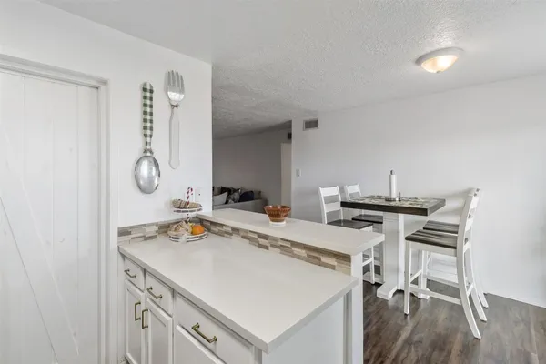 a view of a kitchen with a table and chairs