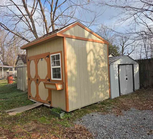 a backyard of a house with barbeque oven table and chairs