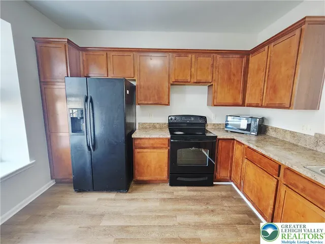 a kitchen with stainless steel appliances granite countertop a refrigerator stove and sink