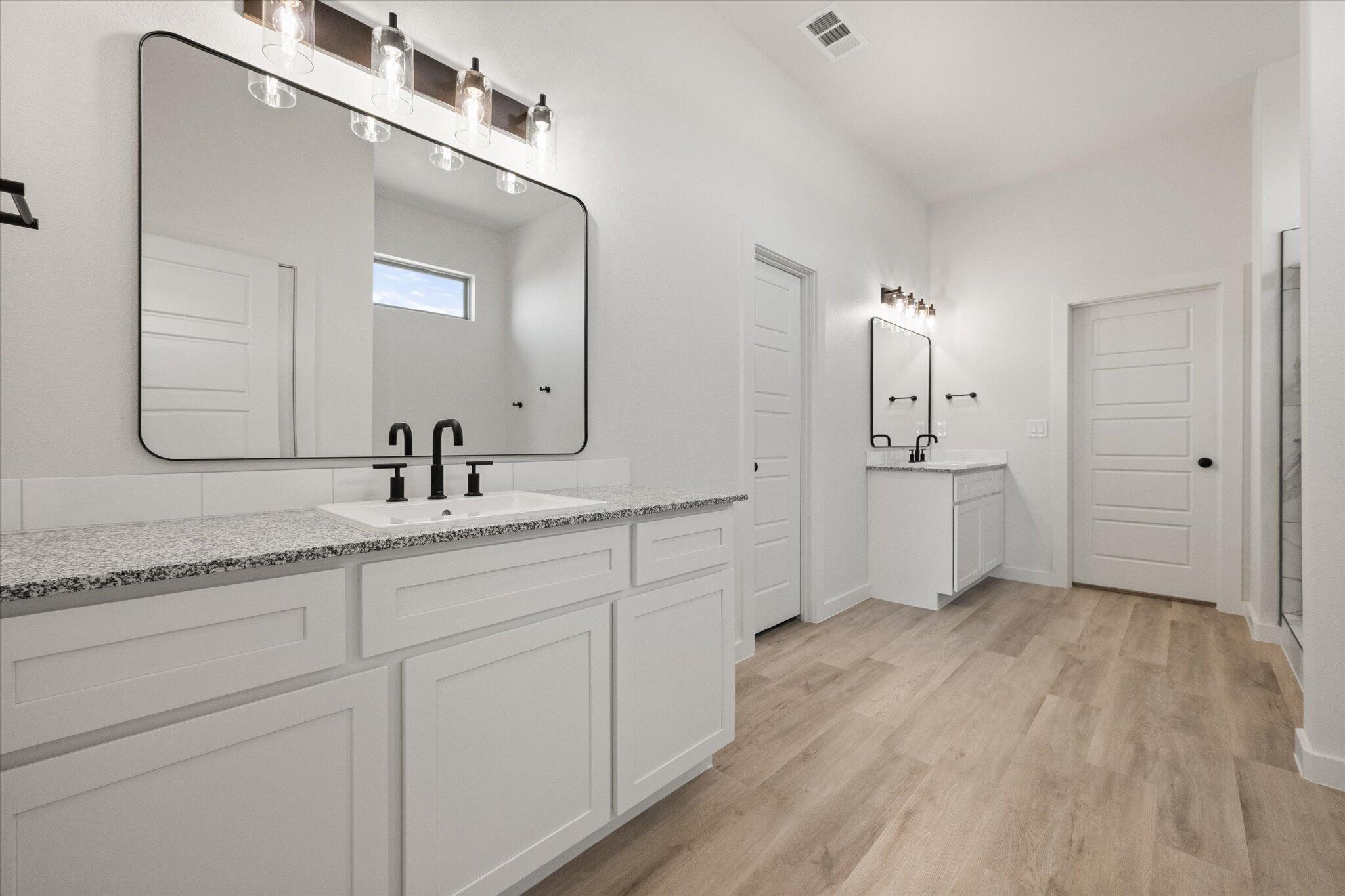 6101 121st Street Lubbock, TX 79424 - Photo 18 of 29 a spacious bathroom with a double vanity sink a mirror and shower