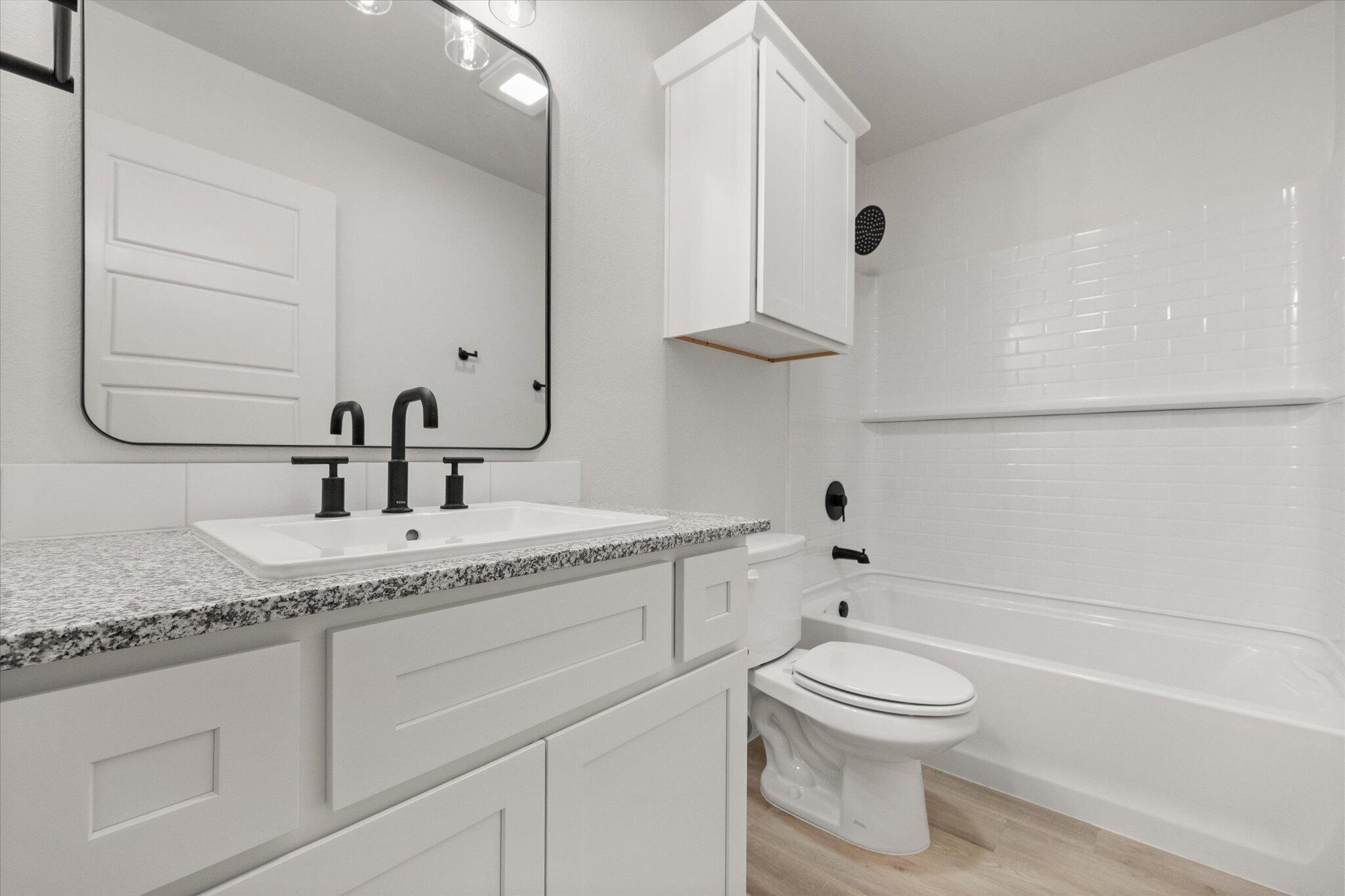 6101 121st Street Lubbock, TX 79424 - Photo 24 of 29 a bathroom with a granite countertop toilet sink and mirror