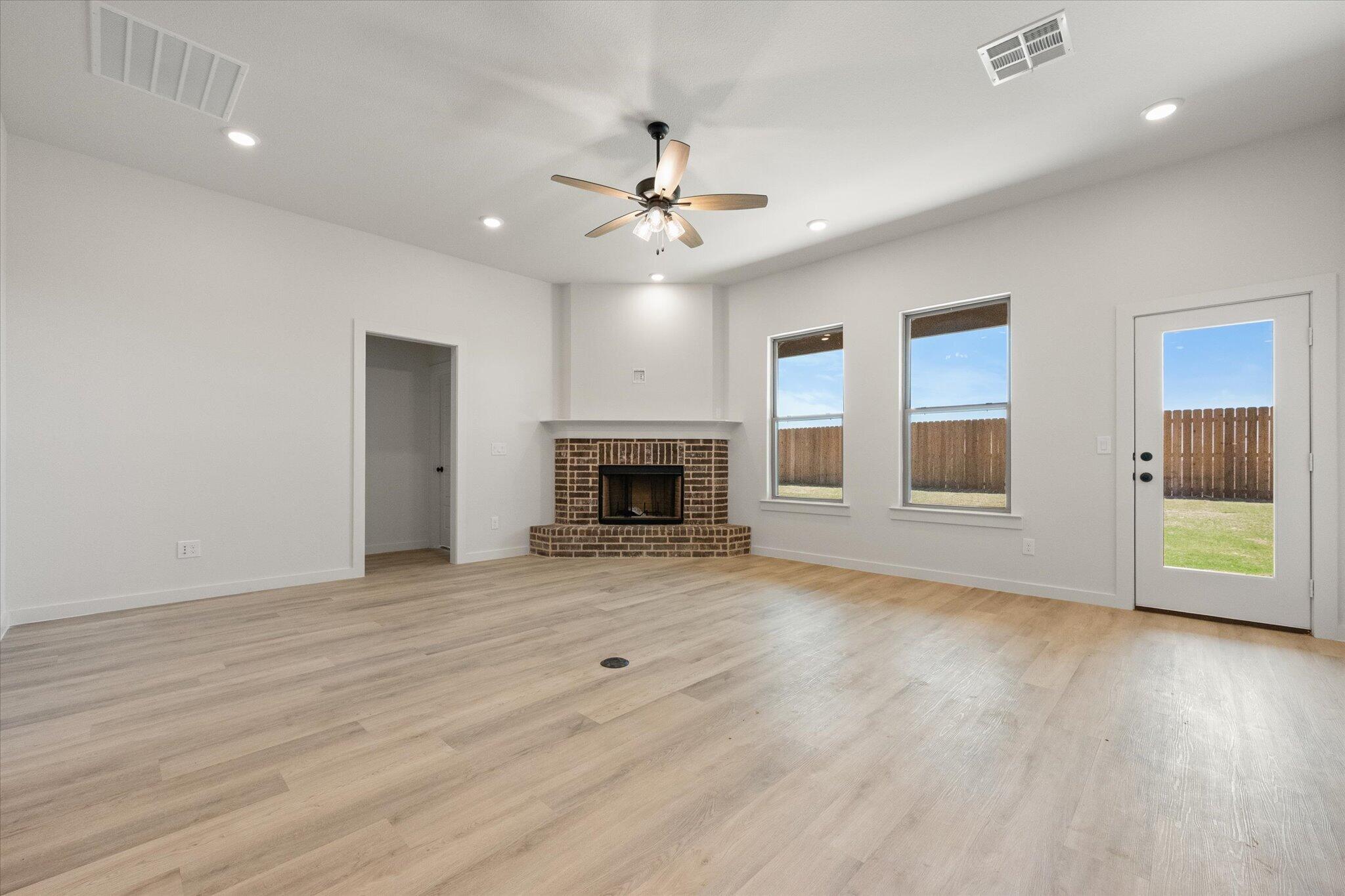 6101 121st Street Lubbock, TX 79424 - Photo 4 of 29 a view of empty room with wooden floor and fireplace