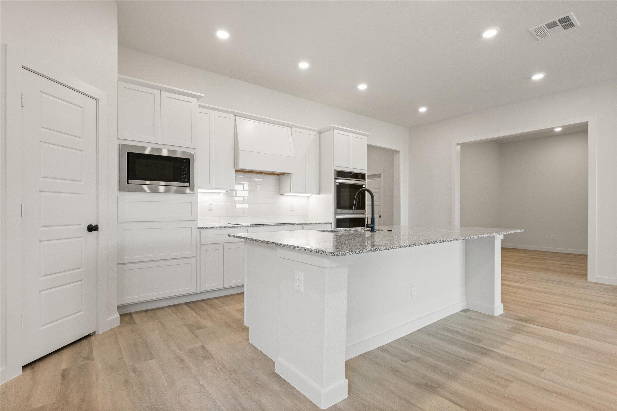 6101 121st Street Lubbock, TX 79424 - Photo 10 of 29 a kitchen with kitchen island white cabinets and stainless steel appliances