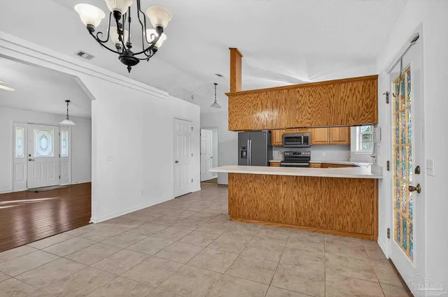 a kitchen with stainless steel appliances granite countertop a stove microwave and refrigerator