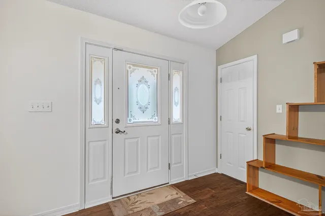 an empty room with wooden floor fireplace and a window