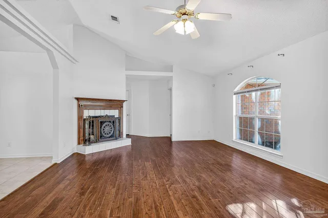 a view of an empty room window wooden floor and fire place