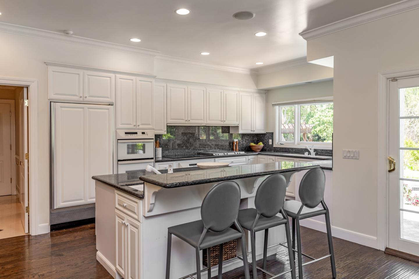 1210 Cañada Road Woodside, CA 94062 - Photo 9 of 60 a kitchen with stainless steel appliances granite countertop a stove top oven a refrigerator a sink and a dining table with wooden floor
